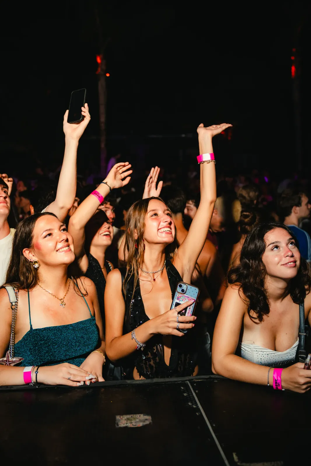 Friends dancing with their hands up at the front of the stage at Move it! Malta